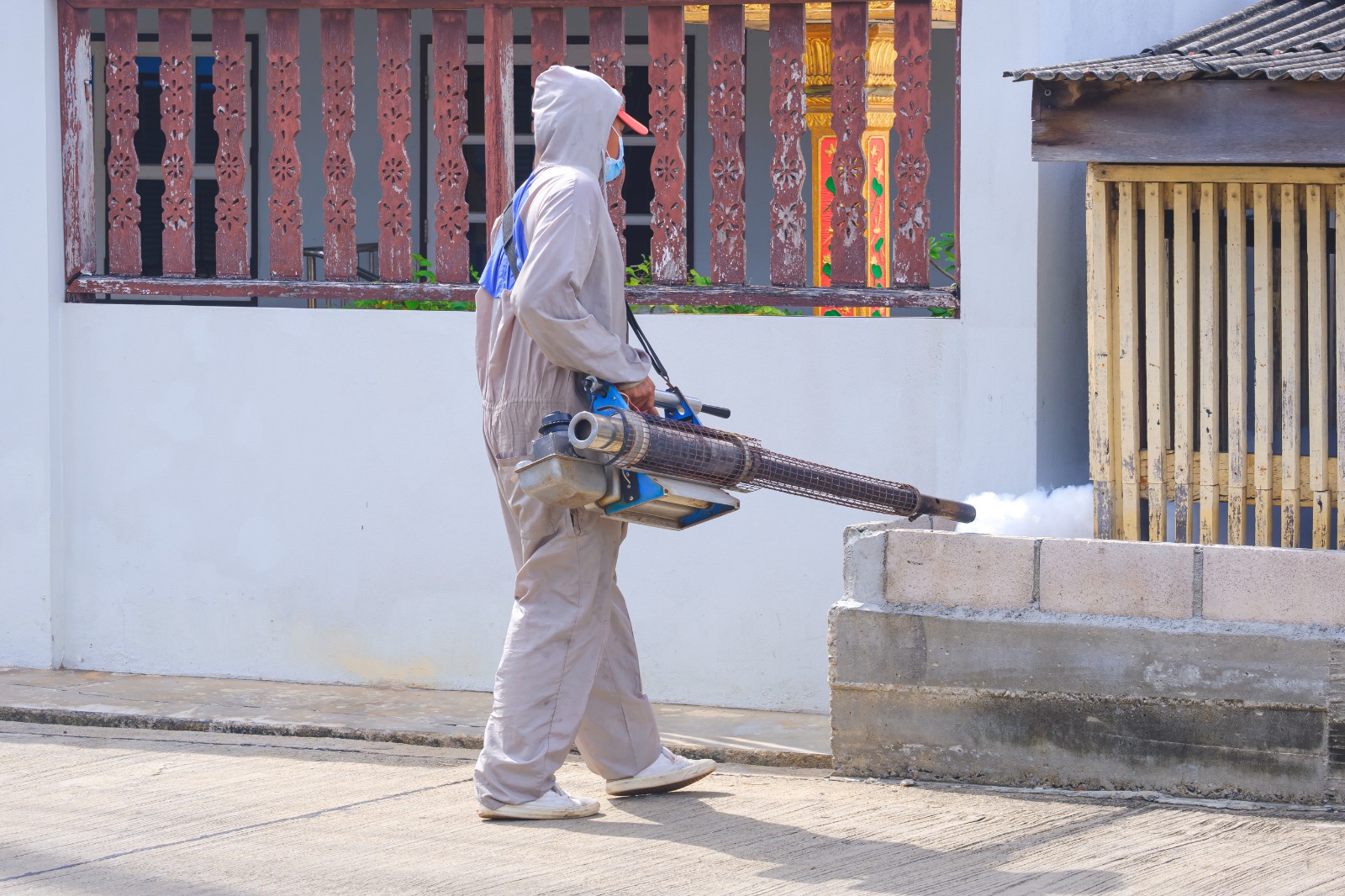 Pegawai pest control dengan hazmat sedang melakukan fumigasi